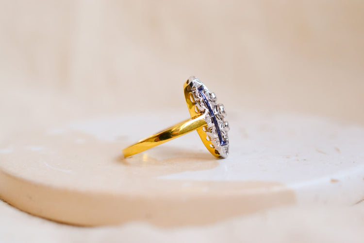 https://www.noircarat.fr/wp-content/uploads/2024/11/Bague-Art-Deco-en-Or-jaune-et-Or-blanc-14-carats-ornee-de-Saphirs-et-de-Diamants.jpg