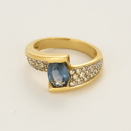 Anillo de aro cruzado de oro amarillo, oro gris, zafiro y diamantes