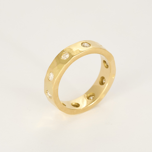Anel tipo aliança em ouro amarelo martelado e diamantes: cerca de 1 quilate