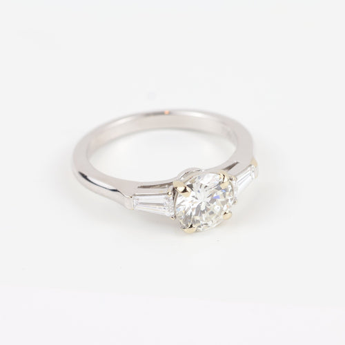 Bague Graff - Bague en or blanc 18 carats sertie d'un diamant central brillant et de diamants latéraux trapézoïdaux. 58 Facettes 130281