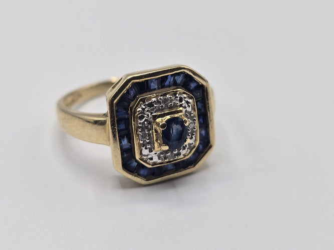 Bague 56 Bague OR Jaune 18k sertie d'un Saphir central, d’éclats de diamants et d'un contour de saphir baguettes 58 Facettes 1-0000448/2