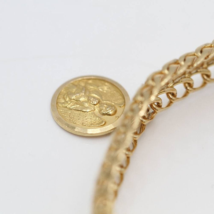 Pulsera articulada con medalla de oro de 18k.