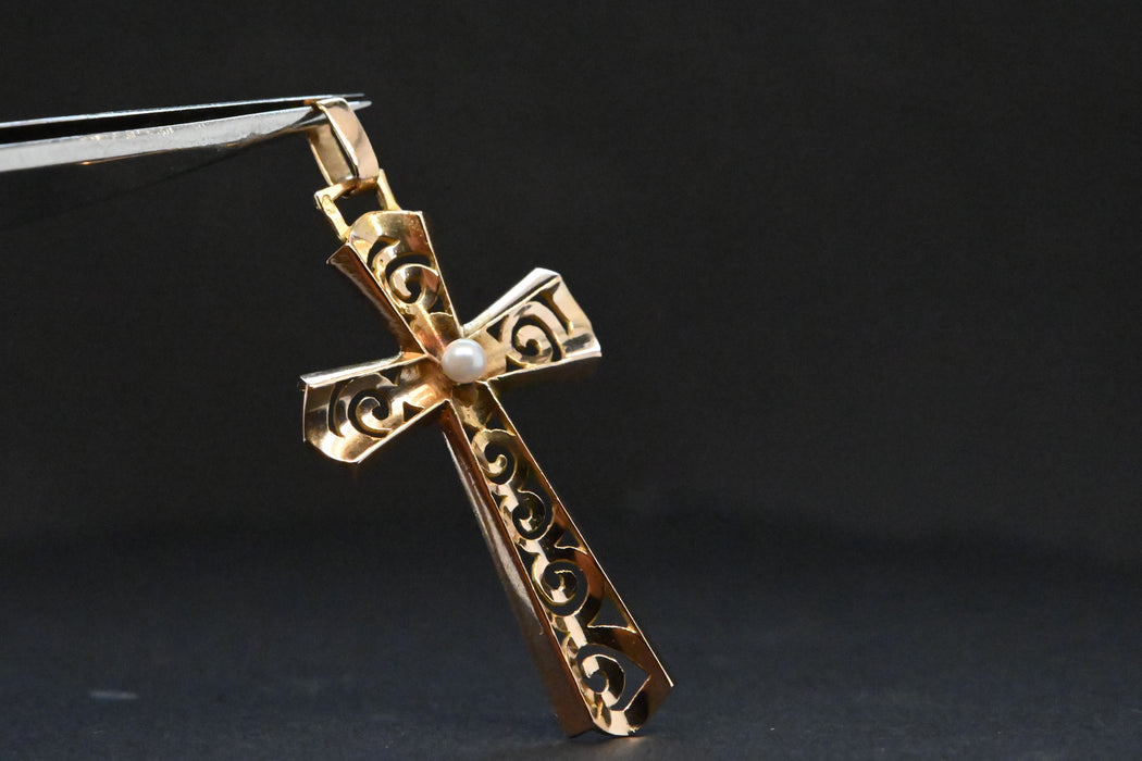 Croce traforata in oro impreziosita da una perla