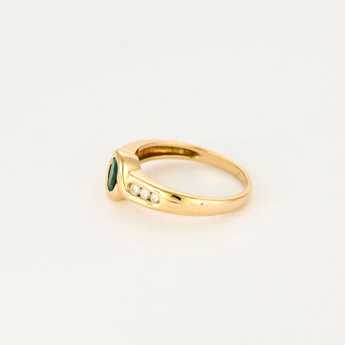 Vintage prsten ze žlutého zlata s diamanty a smaragdem uprostřed.