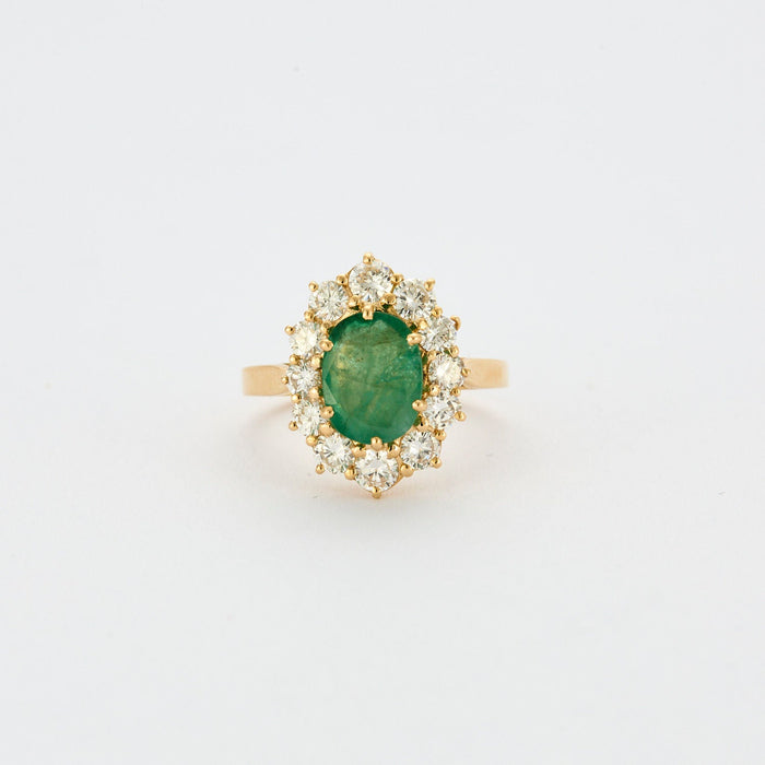 Yellow gold ring with central emerald surrounded by diamonds