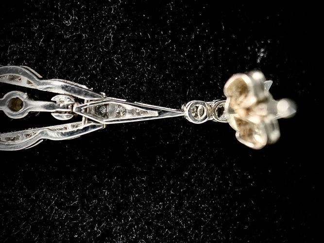 一对镶嵌着明亮钻石的吊坠耳环