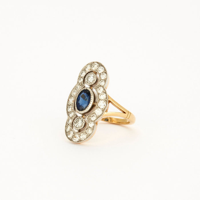 Art Deco Style ring in yellow gold, platinum, diamonds and sapphire center.