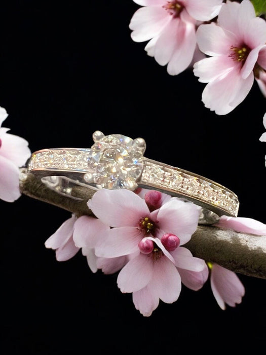 Diamond solitaire surrounded by diamond pavé, gold ring