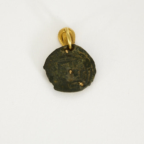 Old twisted yellow gold medal-cross on stone. 