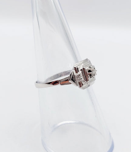 Bague 53 Bague art deco or blanc 18k ornée d'un diamant rond dans une monture géométrique finement travaillée (circa 1930) 58 Facettes A04979