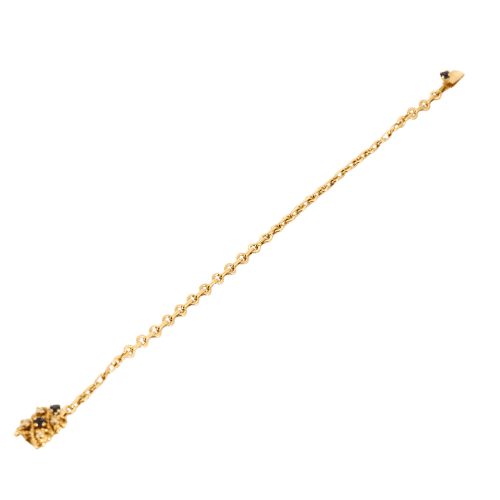 Kierretty keltakultainen rannekoru, jossa safiireja ja timantteja.