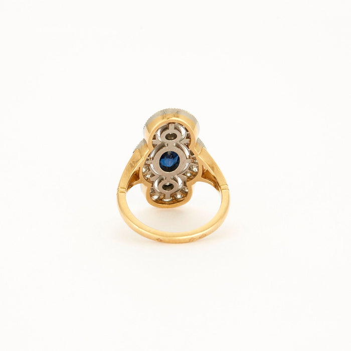 Ring im Art-Déco-Stil aus Gelbgold, Platin, Diamanten und Saphir in der Mitte.