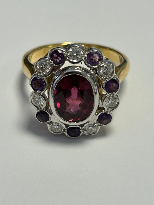 Oval scalloped 2-tone gold ring adorned with a rhodolite