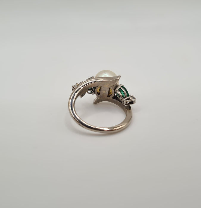 Anillo de oro blanco engastado con una perla cultivada, diamantes y esmeraldas.