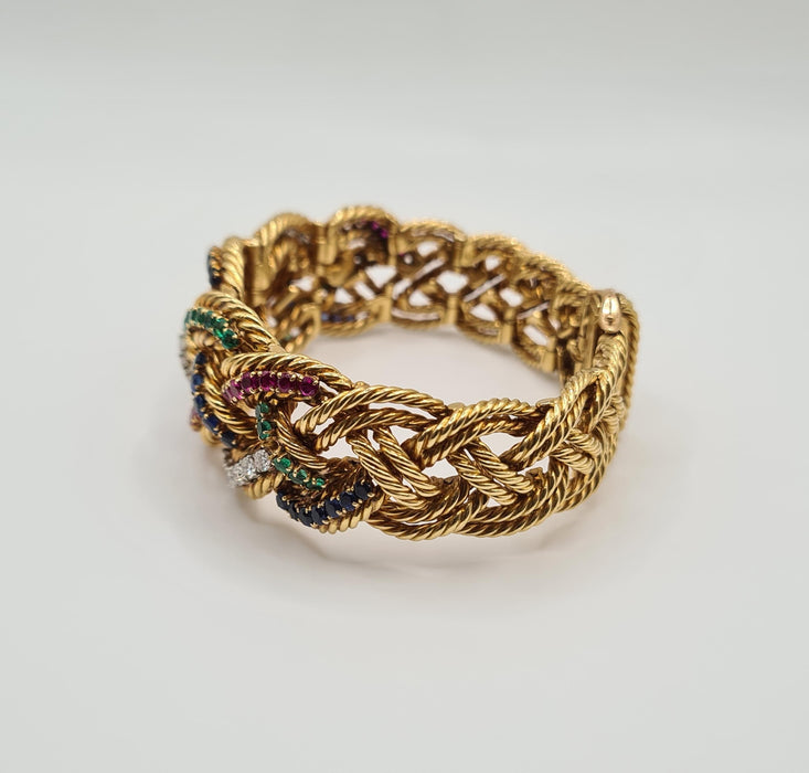 Boucheron - Brazalete de oro amarillo engastado con diamantes, zafiros, esmeraldas y rubíes.