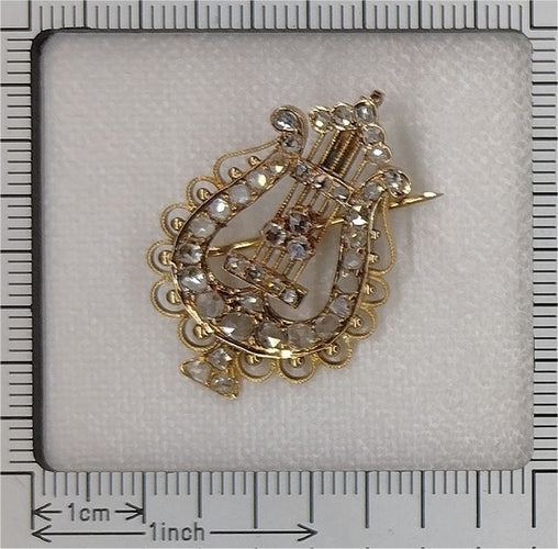 Diamanti e armonia: la spilla-ciondolo a lira in oro degli anni 1870 