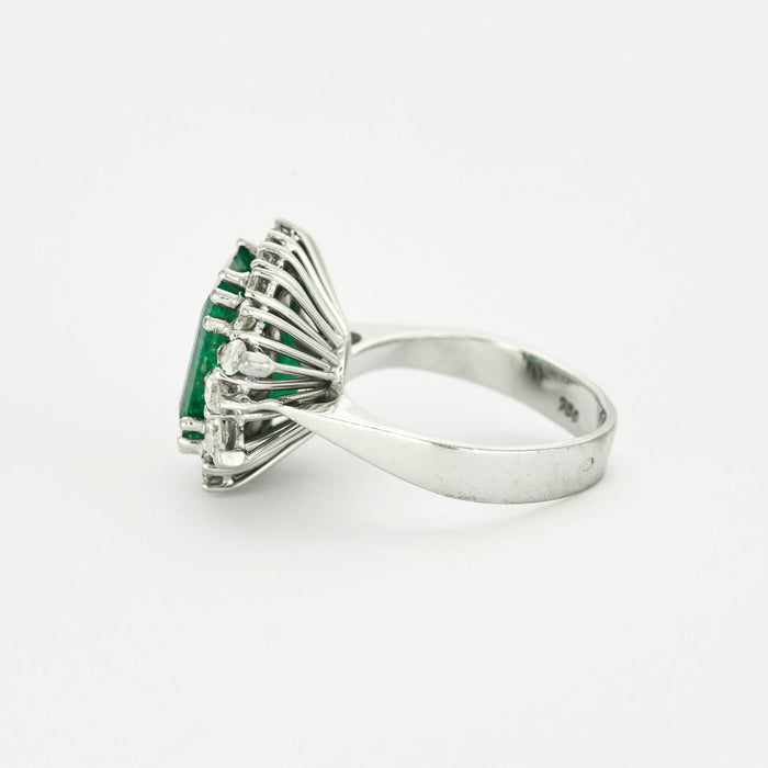 Smaragdgroene ring omgeven door diamanten