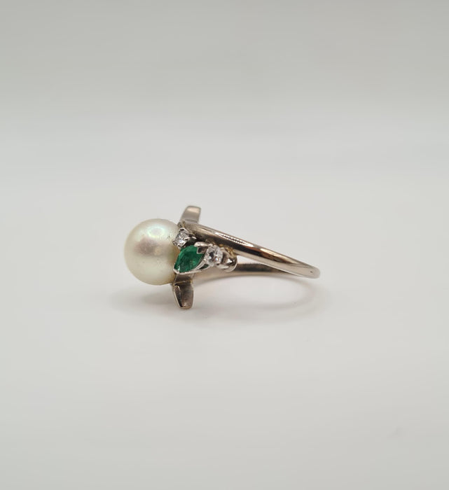 White gold ring set with a cultured pearl, diamonds and emeralds