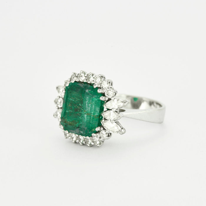 Smaragdgroene ring omgeven door diamanten