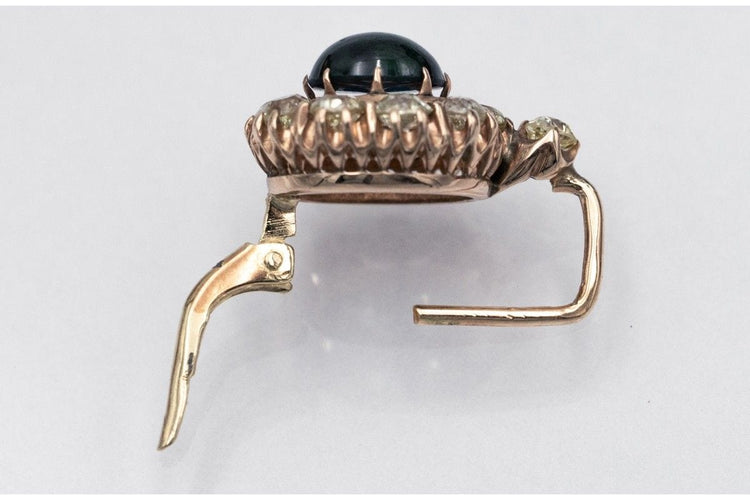 Kultaiset korvakorut, joissa on timantteja ja cabochon-hiottuja safiireja. 