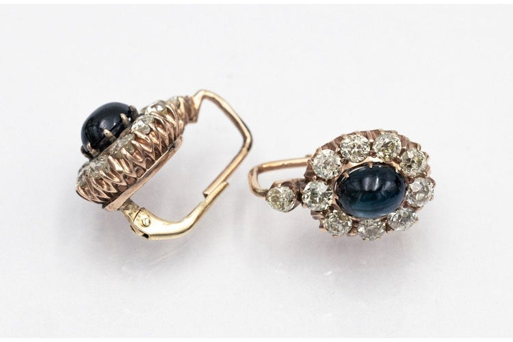 Kultaiset korvakorut, joissa on timantteja ja cabochon-hiottuja safiireja. 