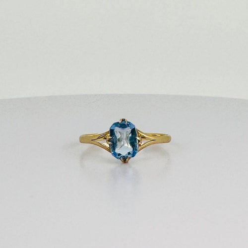 Anillo de oro amarillo con topacio azul ovalado 