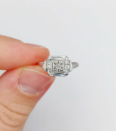 Bague 53 Bague art deco or blanc 18k ornée d'un diamant rond dans une monture géométrique finement travaillée (circa 1930) 58 Facettes A04979