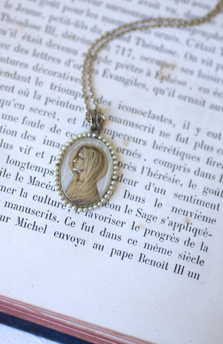 https://cdn.shopify.com/s/files/1/0075/4588/0666/products/medaille-religieuse-art-deco-or-blanc-nacre-et-perles-329914.jpg?v=1657830479