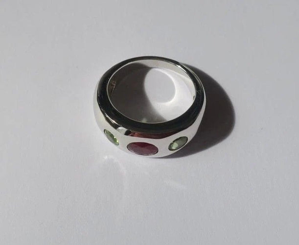 Bague 57 Bague jonc en or blanc, rubis et péridots 58 Facettes