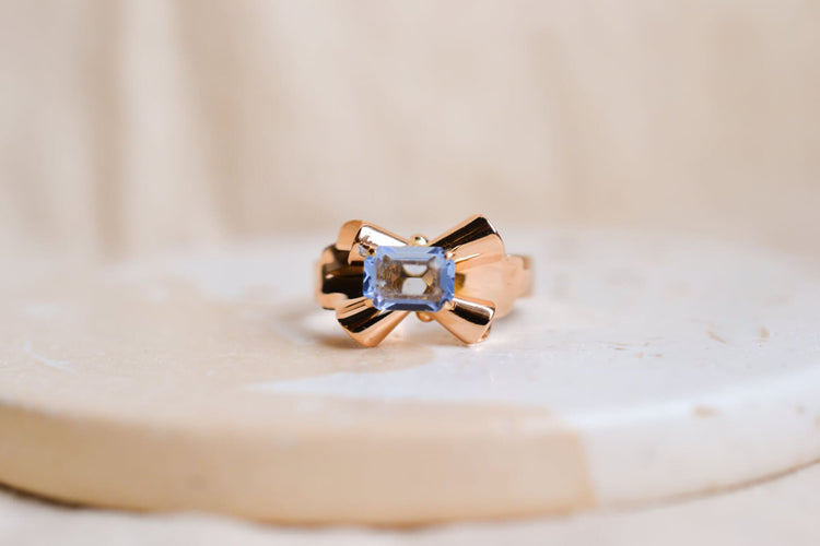 https://cdn.shopify.com/s/files/1/0963/7950/2920/files/Bague-ancienne-en-forme-de-noeud-en-Or-jaune-18-carats-sertie-d_une-pierre-bleue-ciel_2499d699-a409-403a-bee9-439ca1982b22.jpg?v=1779371116