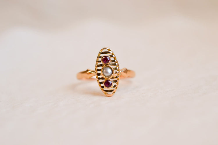 https://cdn.shopify.com/s/files/1/0963/7950/2920/files/Bague-Navette-en-Or-jaune-18-carats-centree-d_une-Perle-entouree-de-pierres-rouges_5fa598dc-2eba-4eeb-9c55-1f8ae23fcff9.jpg?v=1779374039