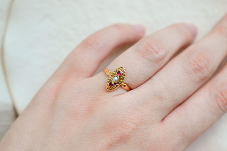 https://cdn.shopify.com/s/files/1/0963/7950/2920/files/Bague-de-fiancailles-ancienne-en-Or-jaune-18-carats-centree-d_une-Perle-entouree-de-pierres-rouges_d7604372-c7c2-40ca-aa10-939b41982b19.jpg?v=1779374046