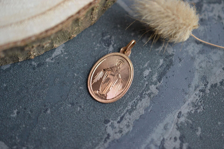 https://cdn.shopify.com/s/files/1/0963/7950/2920/files/Medaille-ovale-en-Or-jaune-representant-la-Jungfru Maria-Marie-gravee-au-dos-_-M.H-25-juin-1893-bijou-retro-1_204c7bf9-26a7-4597-ab0b-e036d98ff831.jpg?v=1779186237
