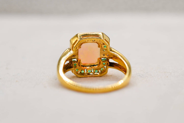 https://cdn.shopify.com/s/files/1/0963/7950/2920/files/bague-en-or-jaune-ornee-d-une-opale-rectangulaire-entouree-d-emeraudes-rondes-en-serti-rail-et-de-diamants-ronds-bague-femme.jpg?v=1791882347