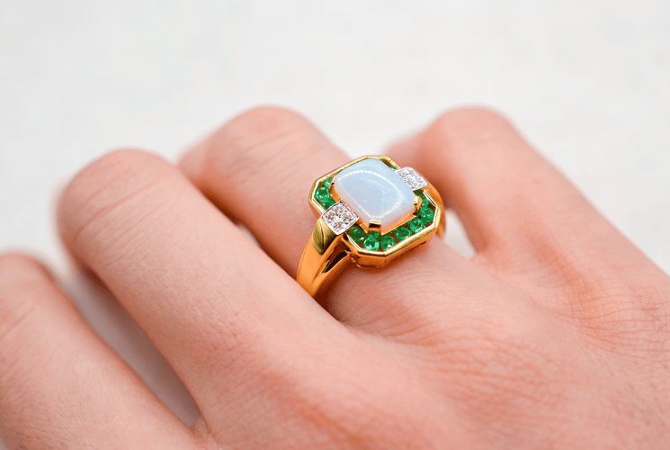 https://cdn.shopify.com/s/files/1/0963/7950/2920/files/bague-en-or-jaune-ornee-d-une-opale-rectangulaire-entouree-d-emeraudes-rondes-en-serti-rail-et-de-diamants-ronds-bague-eco-responsable.png?v=1791882395