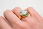https://cdn.shopify.com/s/files/1/0963/7950/2920/files/bague-en-or-jaune-ornee-d-une-opale-rectangulaire-entouree-d-emeraudes-rondes-en-serti-rail-et-de-diamants-ronds-bague-eco-responsable.png?v=1791882395